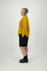 Side view women wearing long shorts with hands in pockets and mustard shirt, Citizen Women