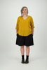 Woman wearing mustard cotton top with sleeves rolled up and shorts Citizen Women 