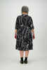 Back view woman wears knee length black and white abstract floral dress Citizen Women