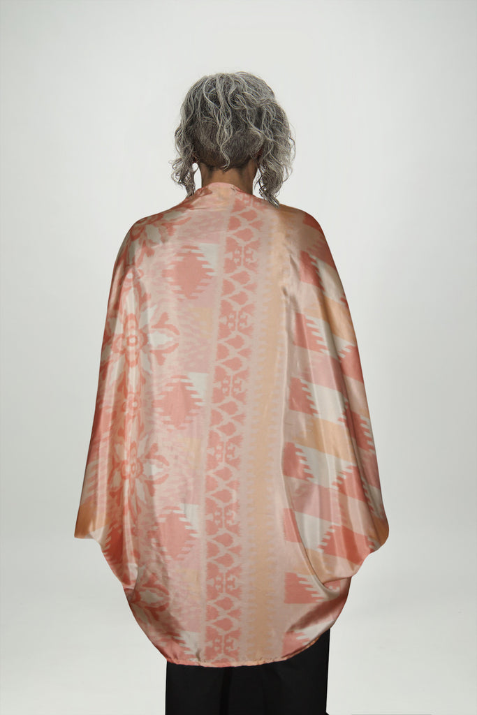 Back view Woman wearing peach coloured, long draped silk shrug, Citizen Women