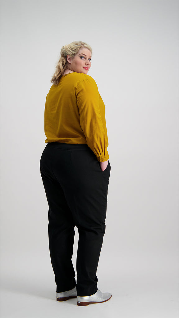 Woman wearing mustard V-neck top tucked into black pants Citizen Women 