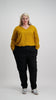 Woman wearing mustard V-neck top tucked into black pants Citizen Women 